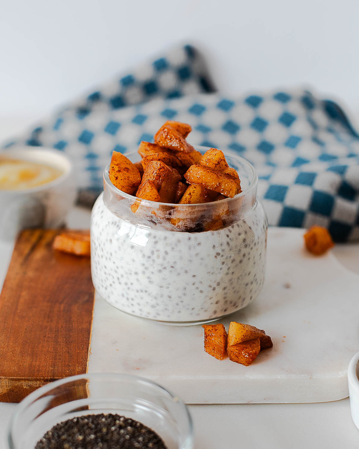Meal prep apple pie chia pudding jars arranged on a cutting board