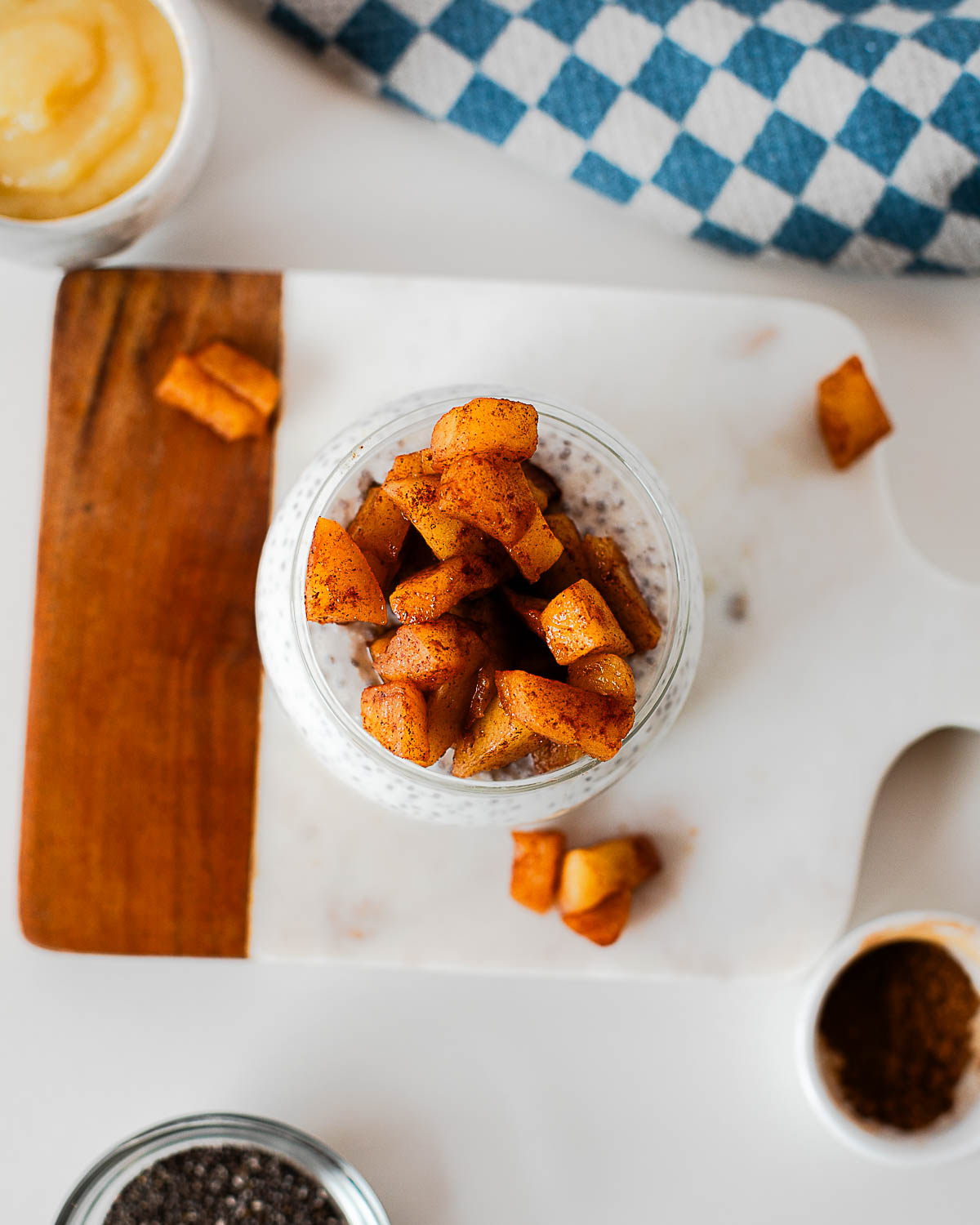 Meal prep apple pie chia pudding jars arranged on a cutting board