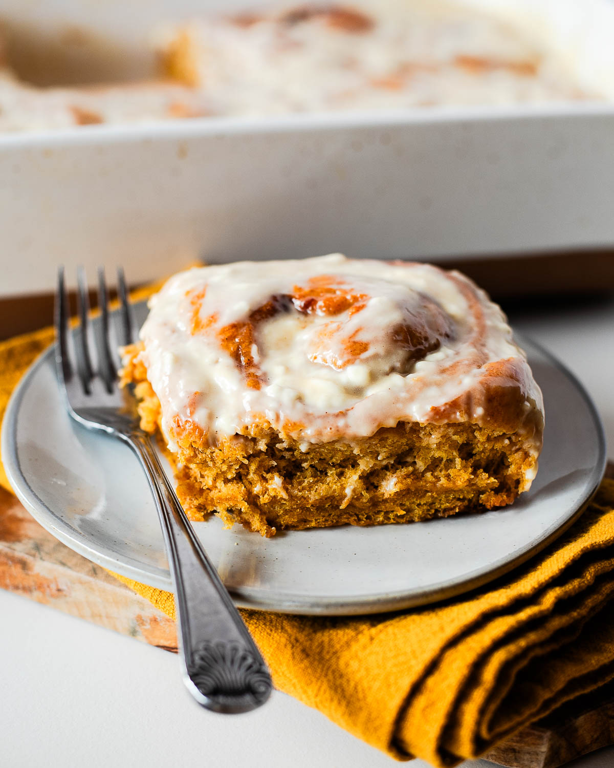Close-up of a sweet potato cinnamon roll with maple cream cheese icing
