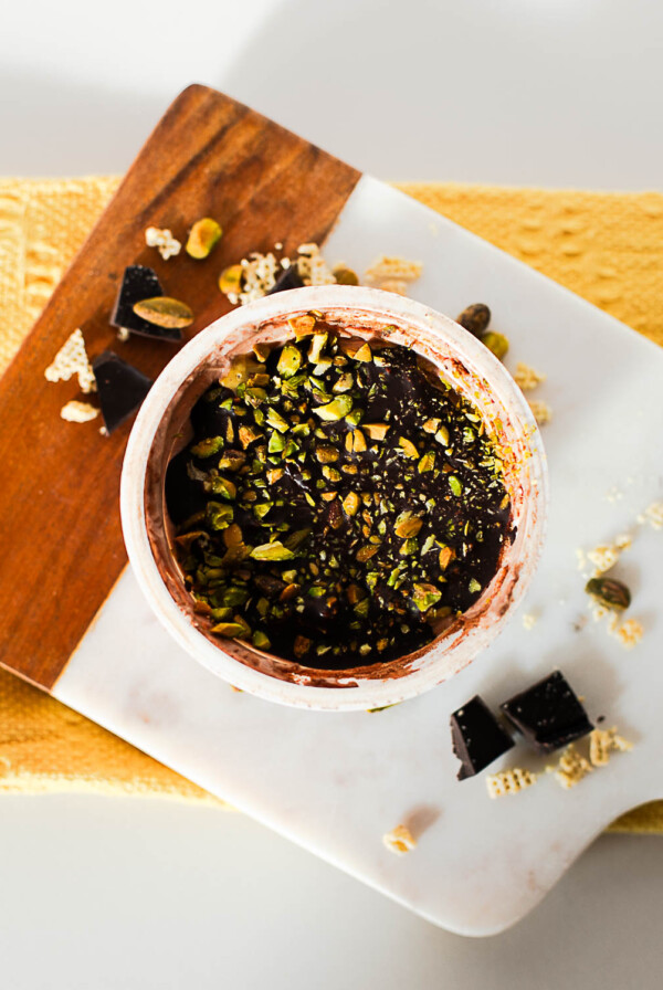 Chocolate pistachio Dubai yogurt cup with hardened chocolate shell and chopped pistachios on top