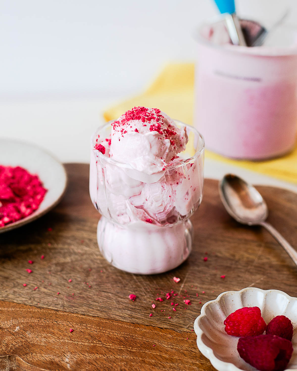 Creamy raspberry protein ice cream scooped into a glass dessert cup and topped with crushed freeze-dried raspberries. An easy high-protein Ninja Creami dessert made with cottage cheese.