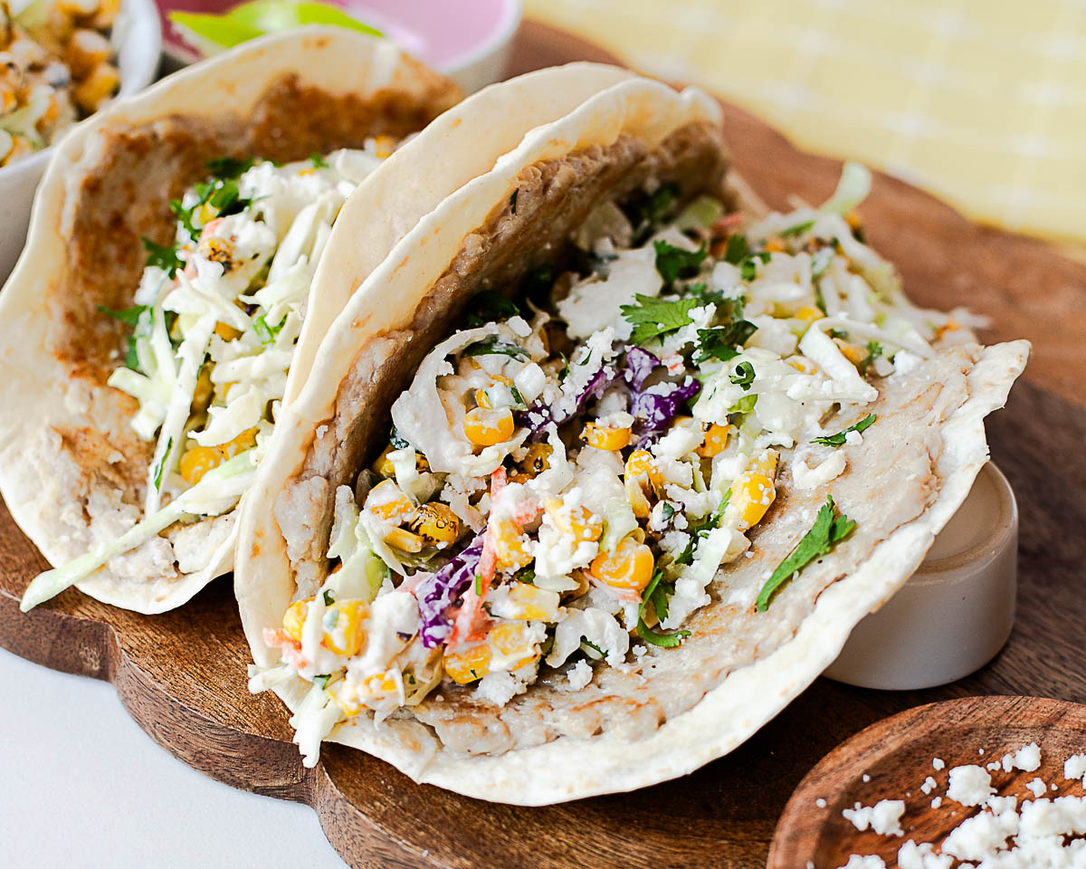 Easy chicken smash tacos topped with creamy street corn slaw, fresh cilantro, and queso fresco.