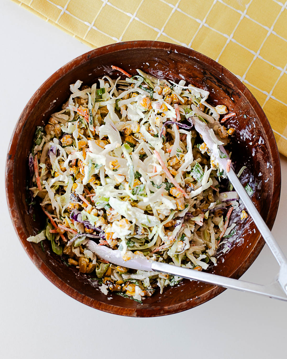 Creamy Mexican street corn slaw with toasted corn, cabbage, queso fresco, cilantro, and green onions.