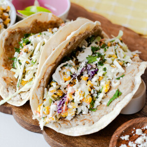 High-protein street corn chicken smash tacos with crispy tortillas, seasoned ground chicken, creamy corn slaw, cilantro, and queso fresco.